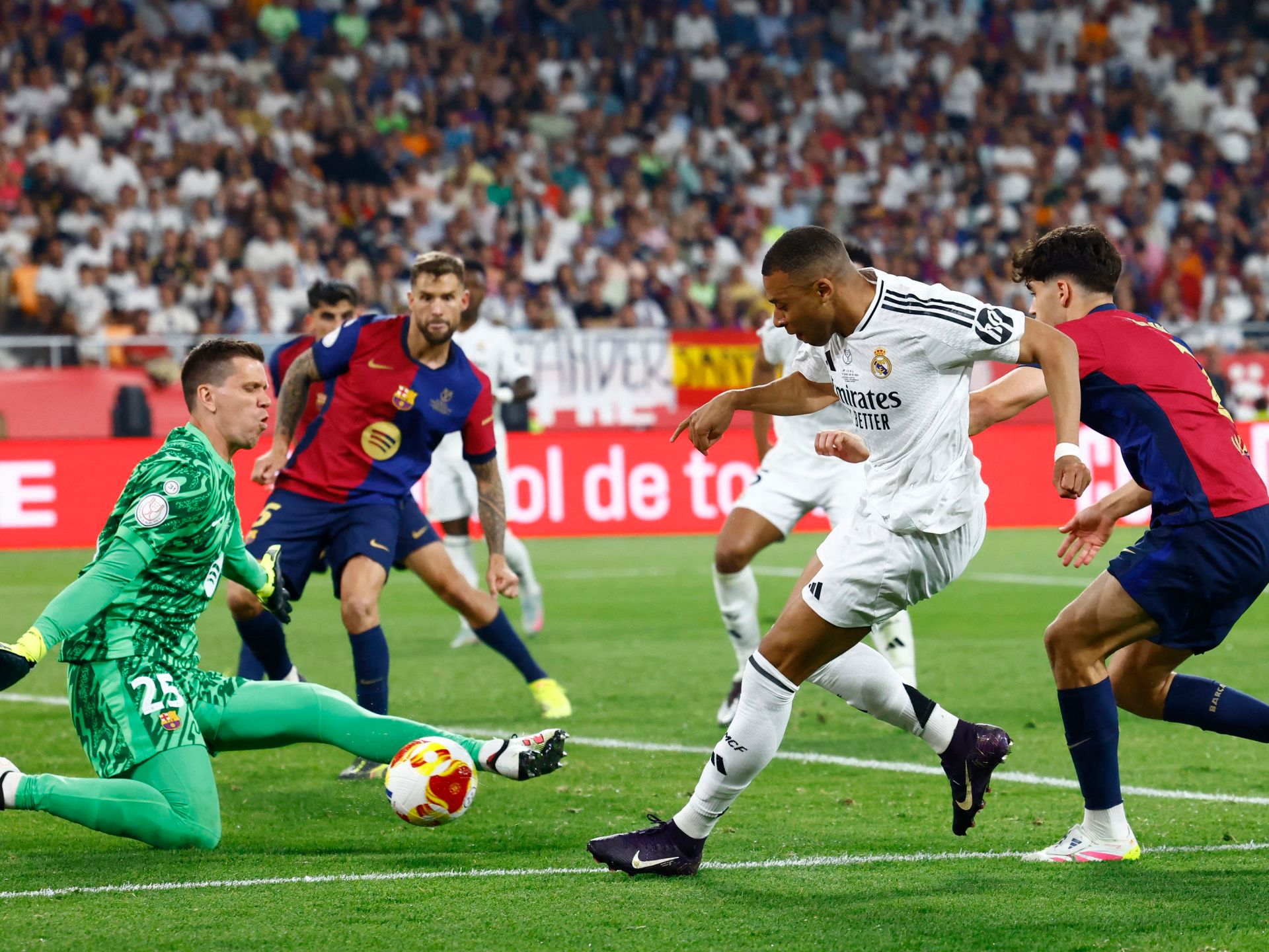 كيليان مبابي لاعب ريال مدريد يراوغ أمام لاعبي برشلونة